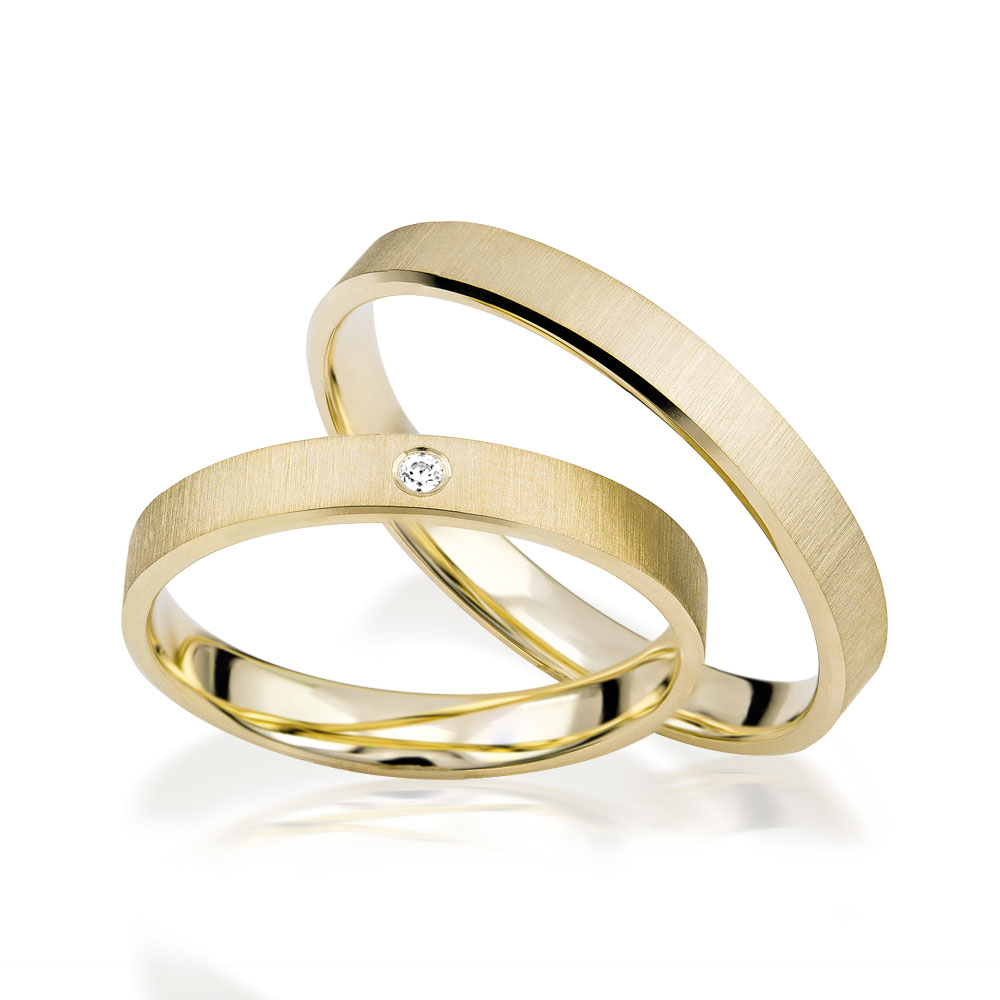 Zwei goldene Ringe mit matter Oberfläche und kleinem Diamanten, elegant