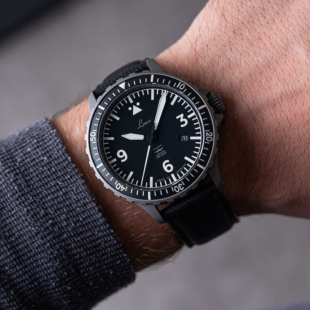 Schwarze Laco Fliegeruhr mit Textilarmband am Handgelenk eines Mannes